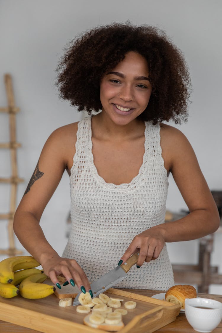 Cheerful Black Woman Cutting Banana For Breakfast