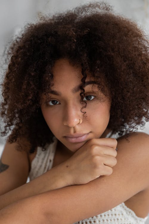 Charming African American female with Afro hairdo and natural skin looking at camera