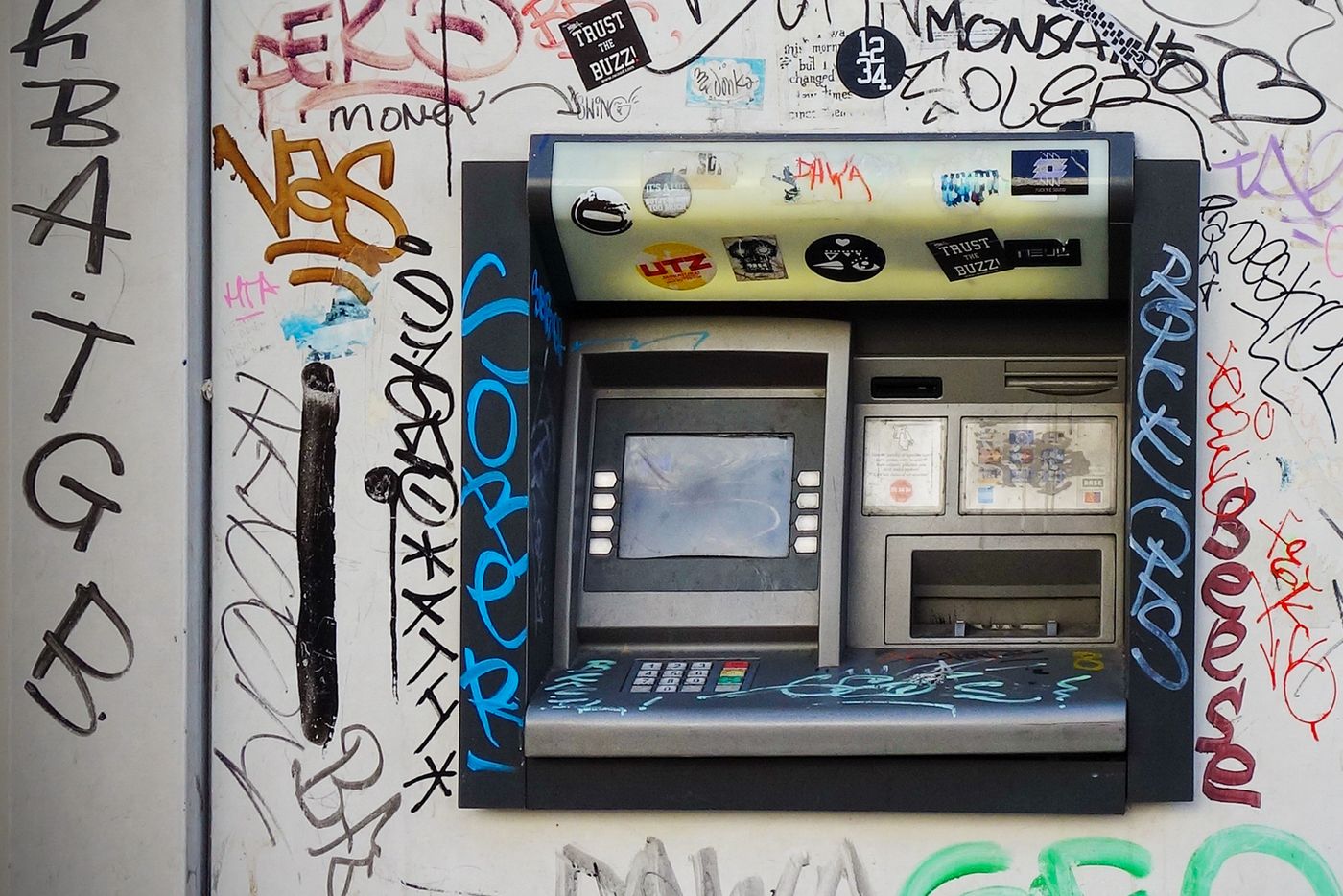 An ATM machine set into a wall in a European city street