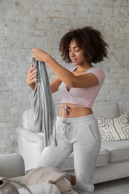 Sonriente Mujer Negra Doblando La Ropa Durante Las Tareas Del Hogar