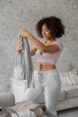 Smiling black woman folding clothes during housework