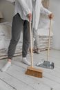 Anonymous women sweeping floor during housework at home
