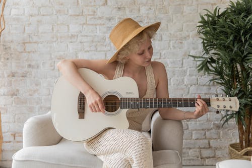 Mujer Tranquila Tocando La Guitarra Acústica En El Acogedor Apartamento