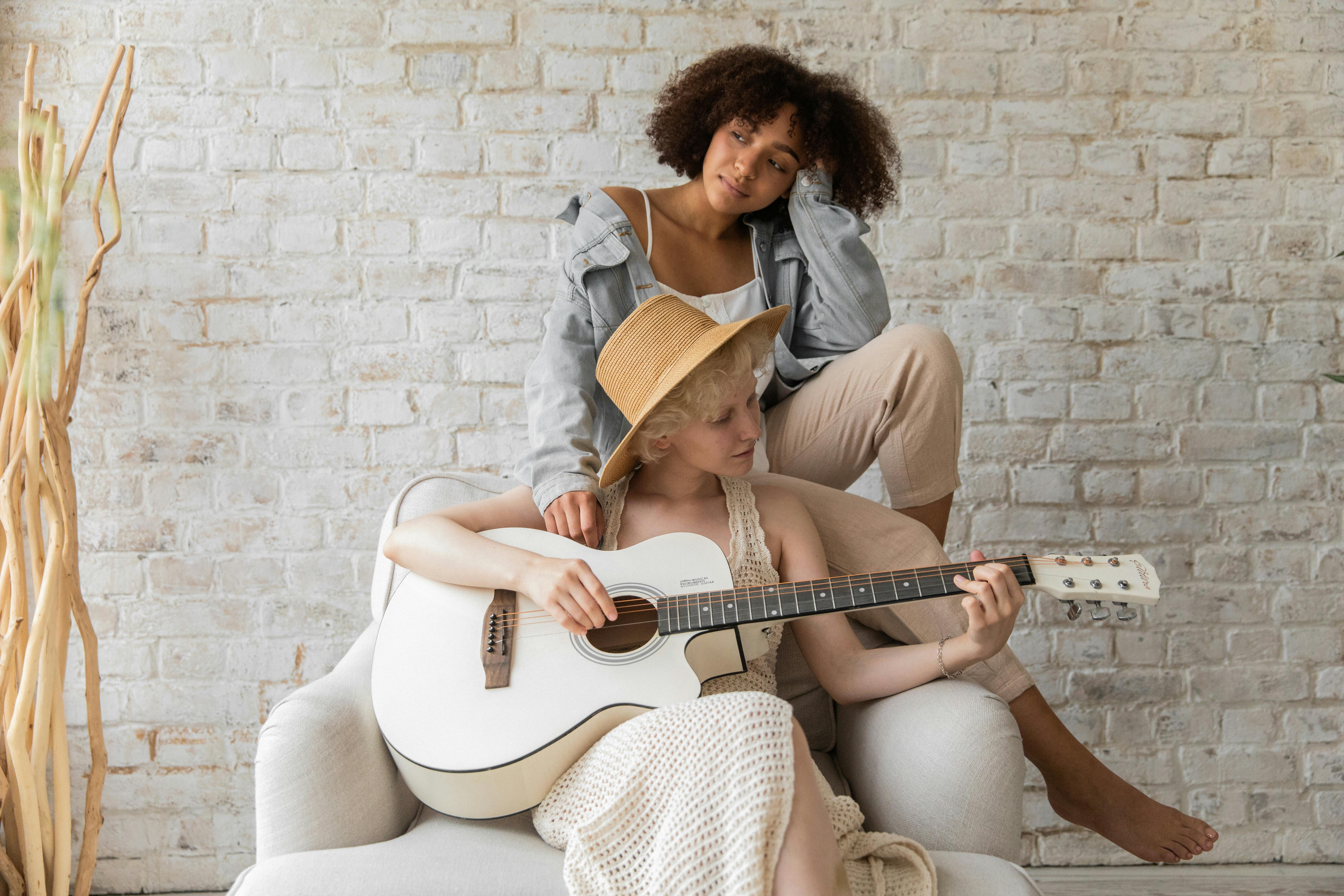 musician playing guitar for black woman