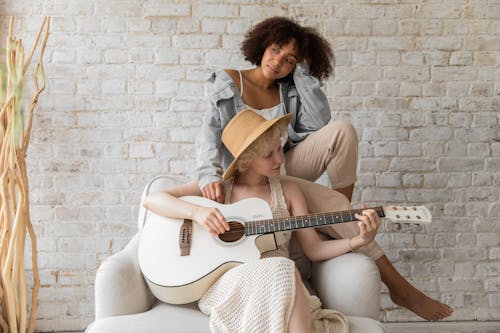 Musician playing guitar for black woman