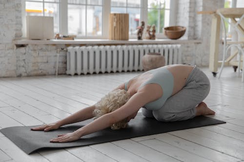 Anonymous woman stretching body in Extended Child s yoga pose