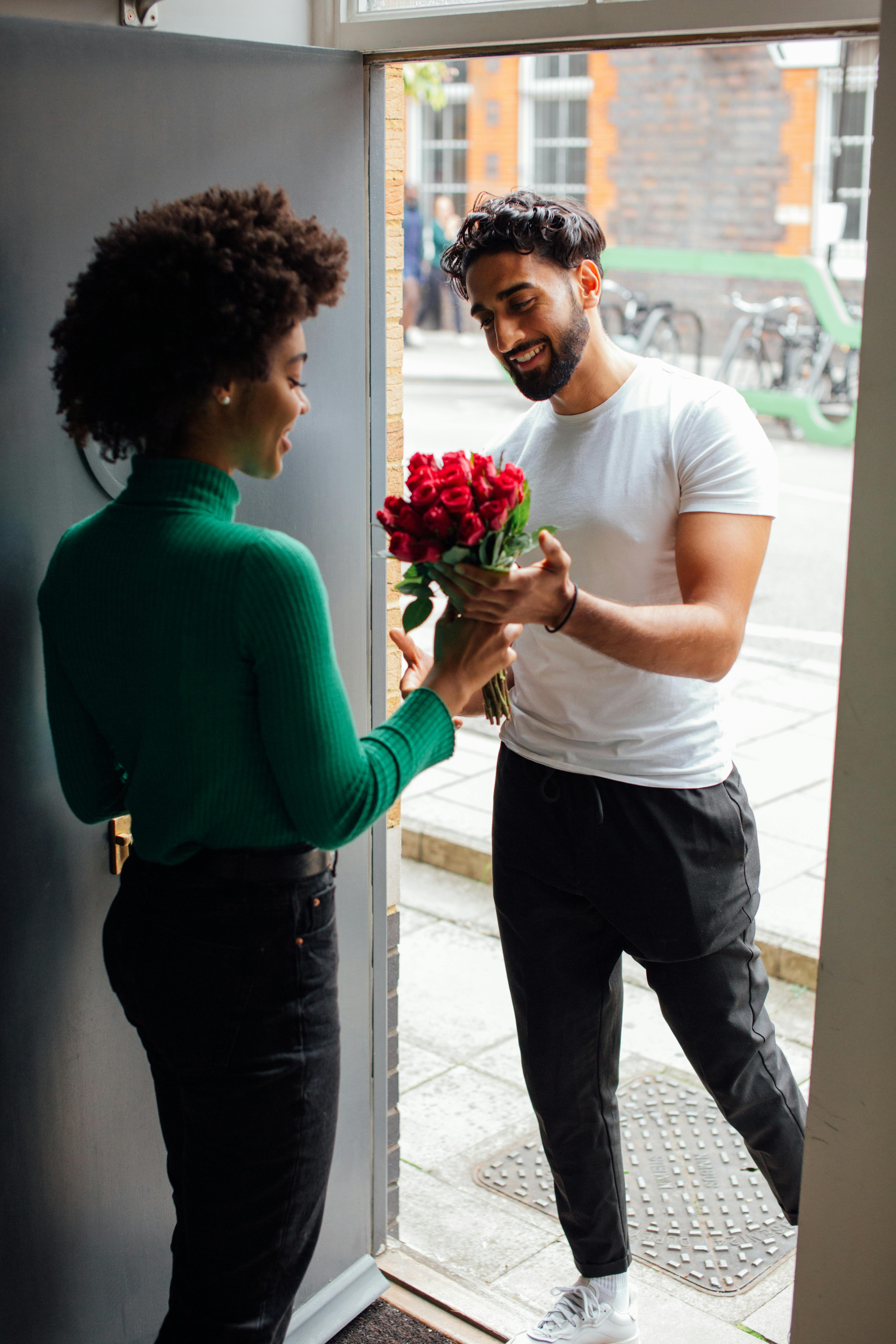 man giving flowers to a woman