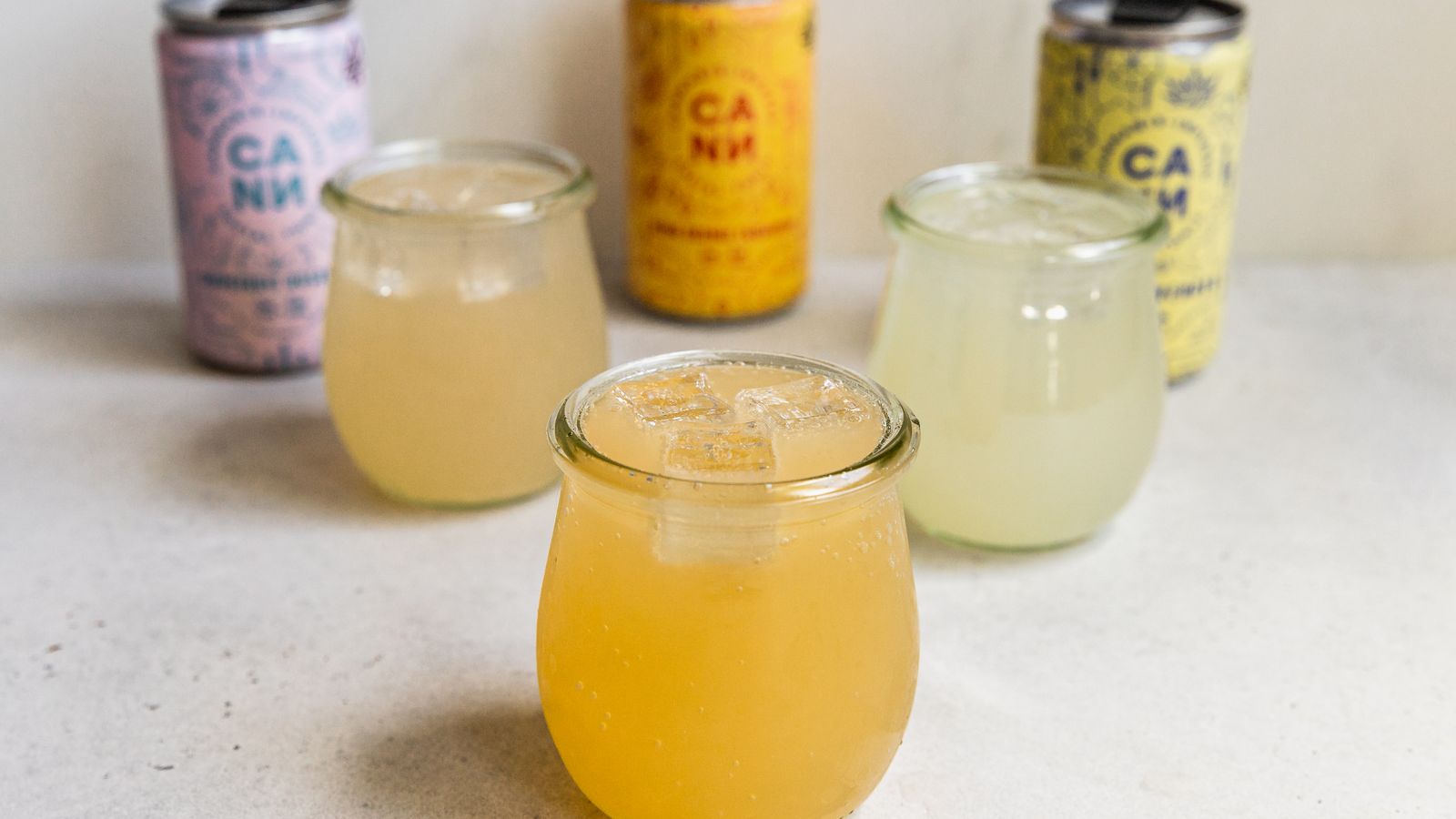 A selection of vibrant CBD-infused drinks showcased in glasses and cans.