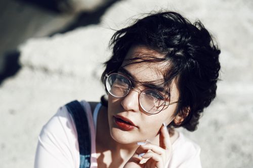 Free Stylish portrait of a young woman with glasses and short hair outdoors. Stock Photo