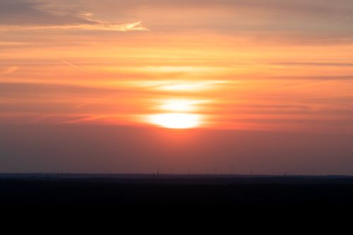 Free Breathtaking sunset over windmills in Reken, Germany. Vibrant orange sky and tranquil horizon. Stock Photo