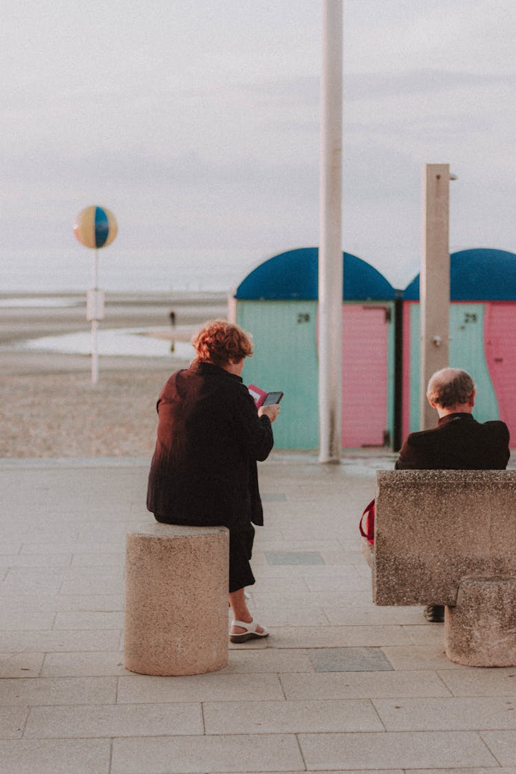 Anonymous Woman Reading Electronic Book On Street Near Ocean