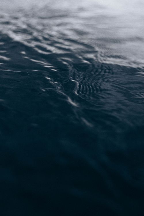 Free From above of wavy sea with fast water flow and shiny surface in darkness Stock Photo