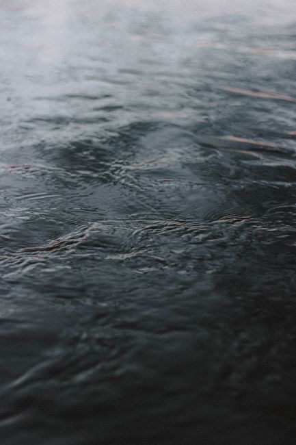 From above background of dark heavy water rippling in cold day in soft light