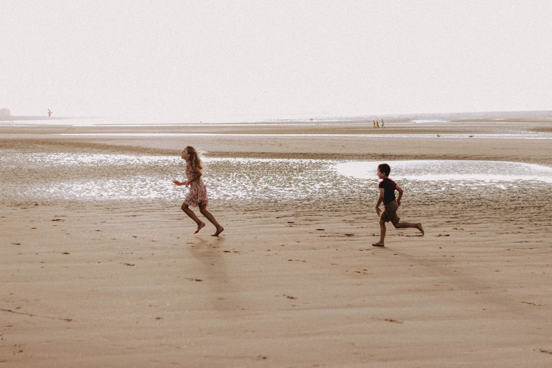 Free Kids running on sandy beach Stock Photo