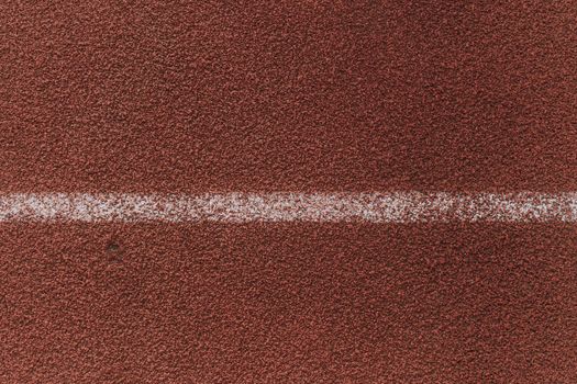 Top view of faded painted white line on rubber special coating of playground