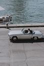 Vintage silver automobile parked near pier