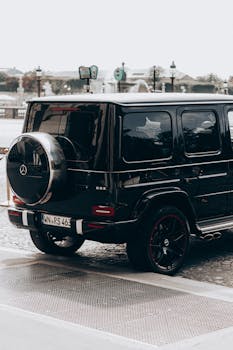 Stylish black SUV parked on a cobblestone city street, showcasing modern design and urban lifestyle.