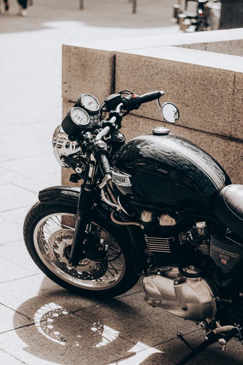 Free Black aged motorcycle with heavy wheels standing on local street of city on sunny day Stock Photo