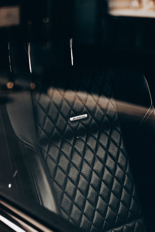 Through glass of expensive car black leather front seat in rays of sunlight