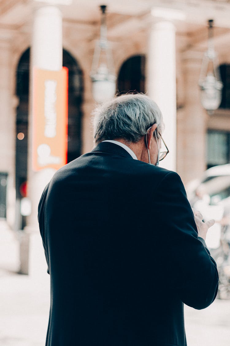 Gray Haired Man In Black Suit On Street