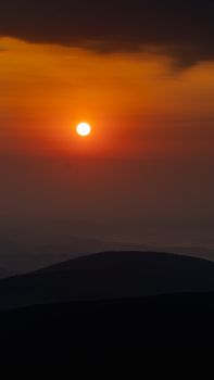 Captivating sunset over mountains during the golden hour, creating a dramatic silhouette.