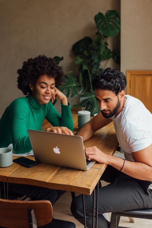 Free Two colleagues collaborating on a project using a laptop in a modern office setting. Stock Photo