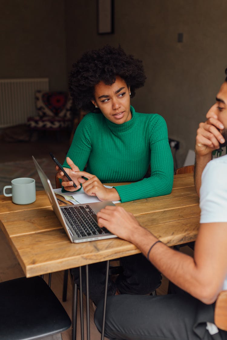 A Couple Using A Laptop And A Smartphone