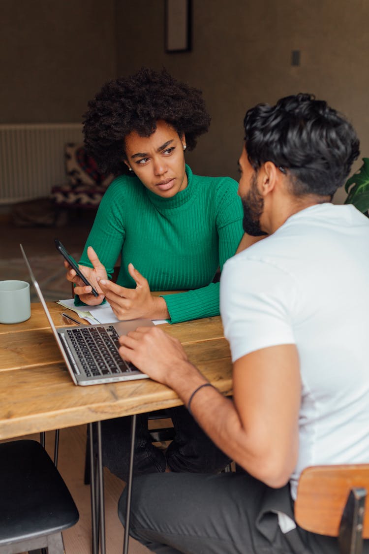 A Man And Woman Having Conversation While Working Together