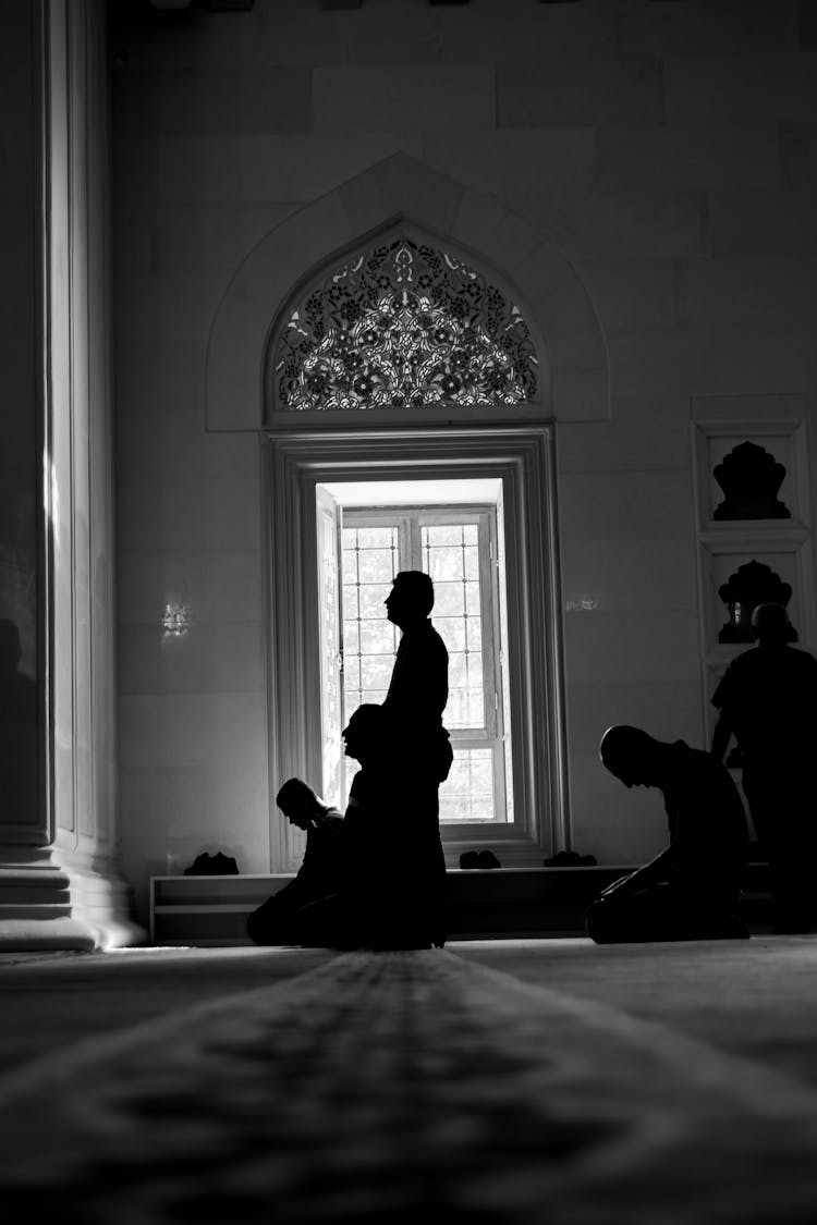 Silhouettes Of People Praying In Mosque