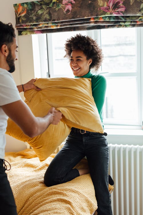 Woman Playing Pillow Fight with a Man
