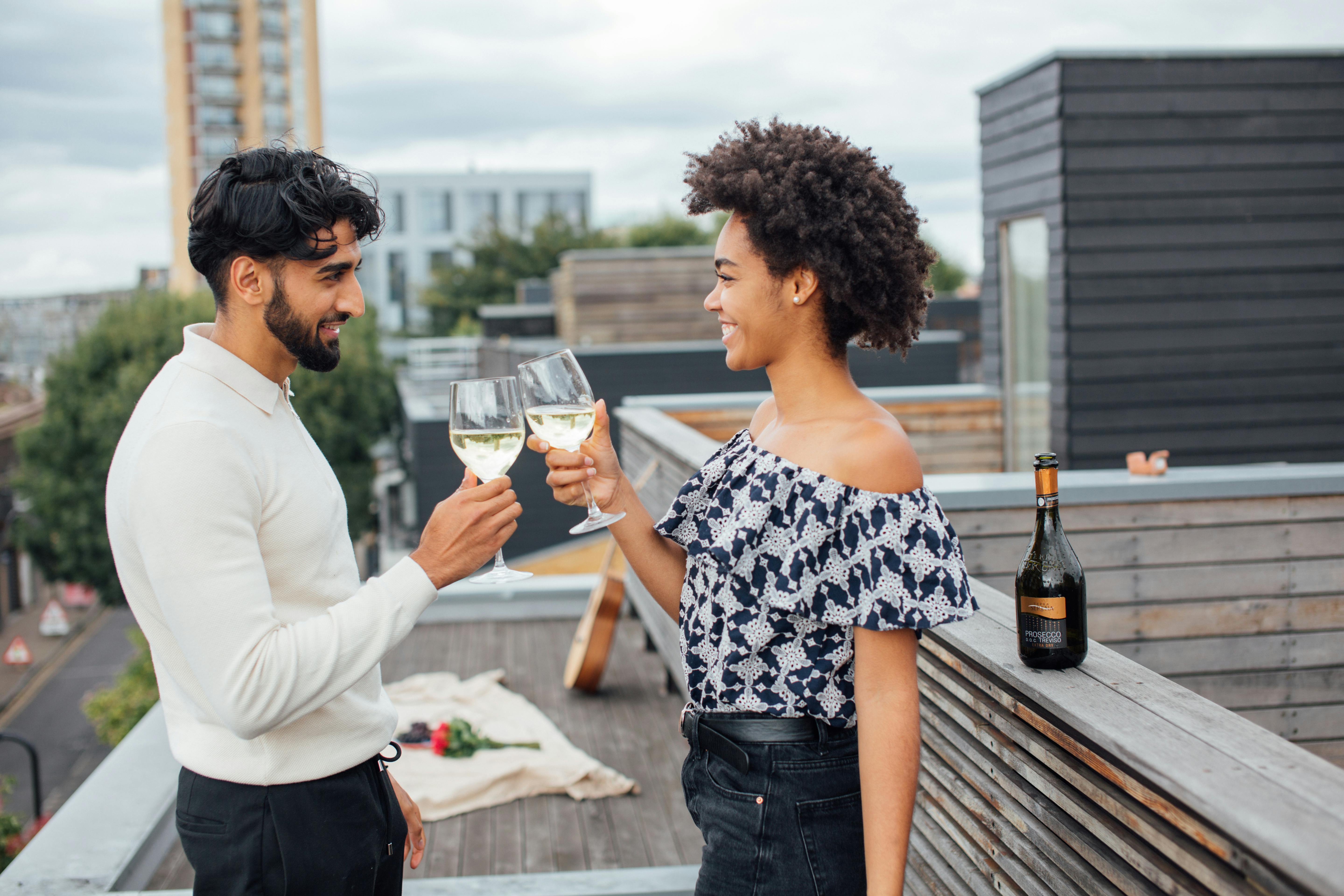 a couple toasting their glasses with white wine