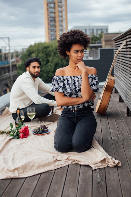 Vrouw In Zwart Wit Bloemen Mouwloos Shirt Zittend Op Bruine Houten Stoel