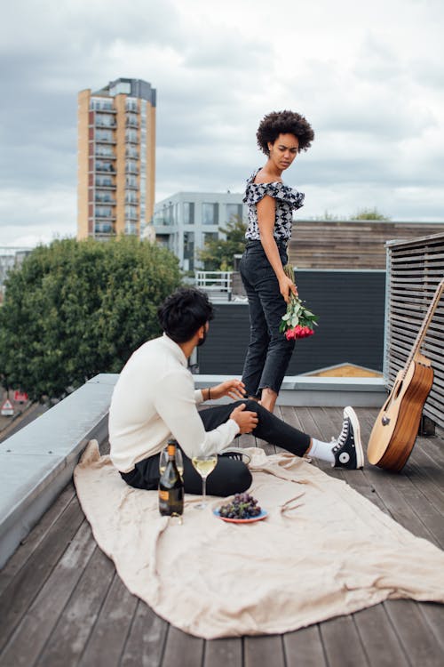 Man and Woman Playing Guitars on Gray Concrete Pavement