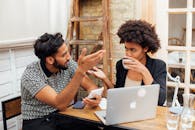 Woman in Black and White Shirt Using Silver Macbook