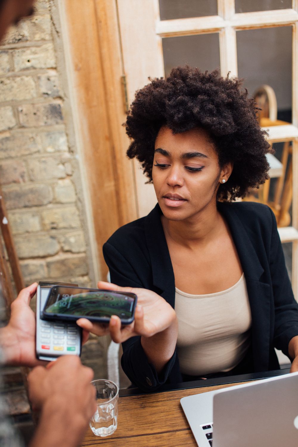 Woman paying with her phone at a cafe counter