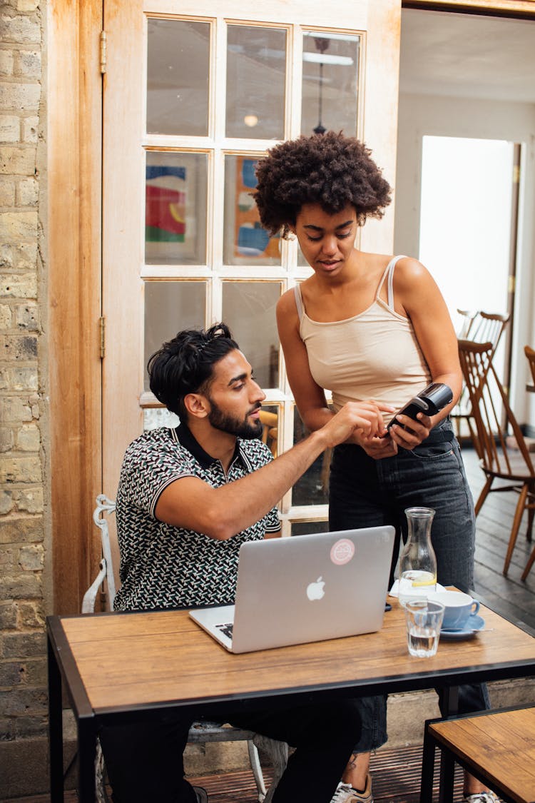 A Man And Woman Talking While Having Transaction