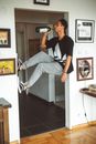 Man in Black Crew Neck T-shirt and Gray Pants Sitting on White Wooden Table