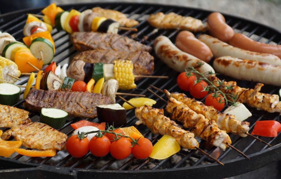 BBQ grill loaded with marinated meats, skewers and sausages