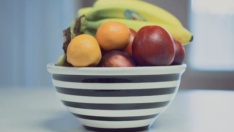 A vibrant assortment of fresh fruits in a striped bowl, ideal for healthy living.