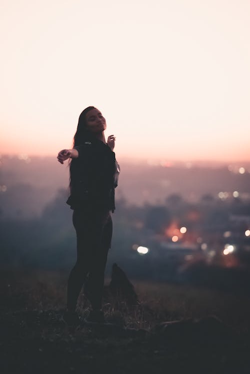 Happy black woman walking on slope at sunset