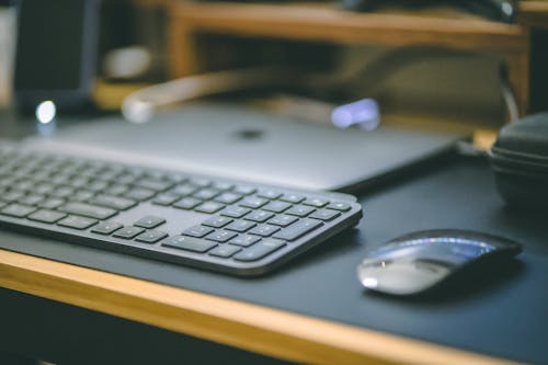 Free Keyboard and Apple Magic Mouse on the Desk Stock Photo
