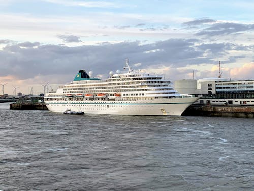 White Cruise Ship on Sea Under White Clouds and Blue Sky