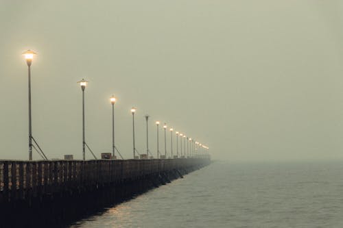 Long pier with tall lights in fog