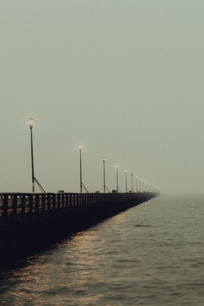 Lamplit pier fading into fog — Griffin Wooldridge on Pexels