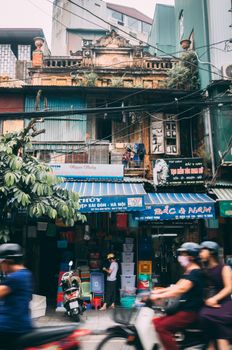 越南的街景中，古老的建筑、商店和路过的滑板车随处可见