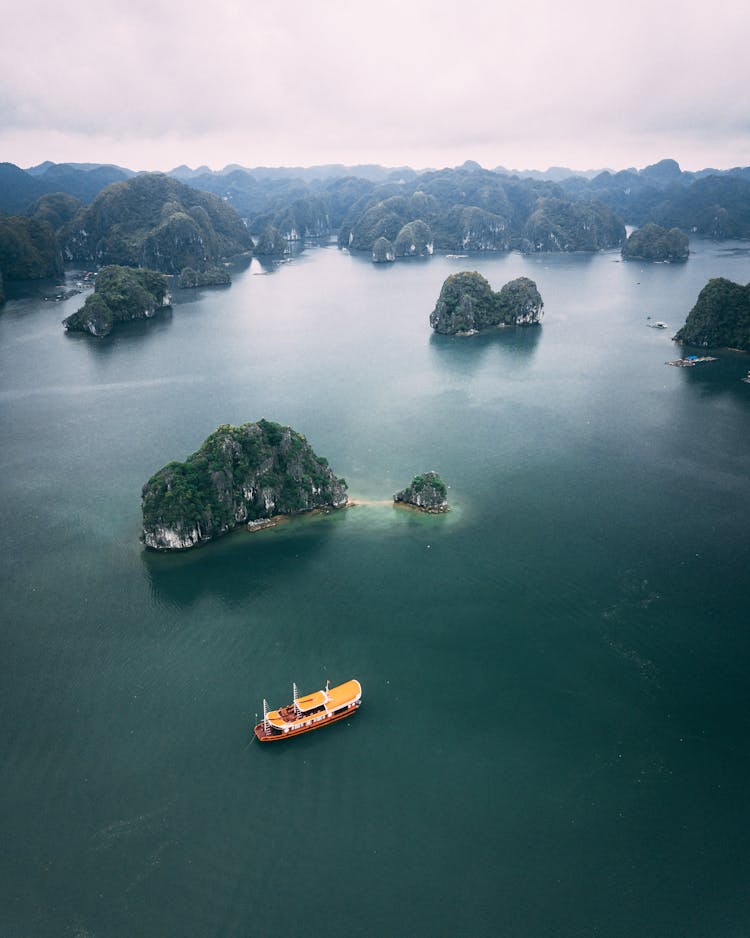 Yellow Boat And Green Islands On A Body Of Water