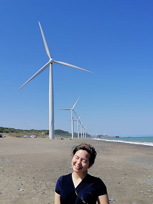 Woman near Wind Turbines on Beach