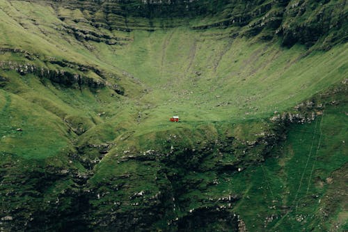 Free Red Car on Road in Between Green Mountains Stock Photo