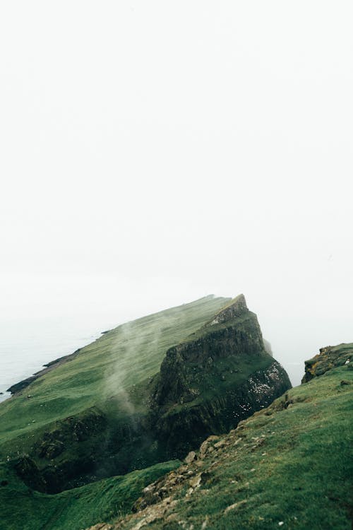 Rock Mountain with Grass Under Clear Sky