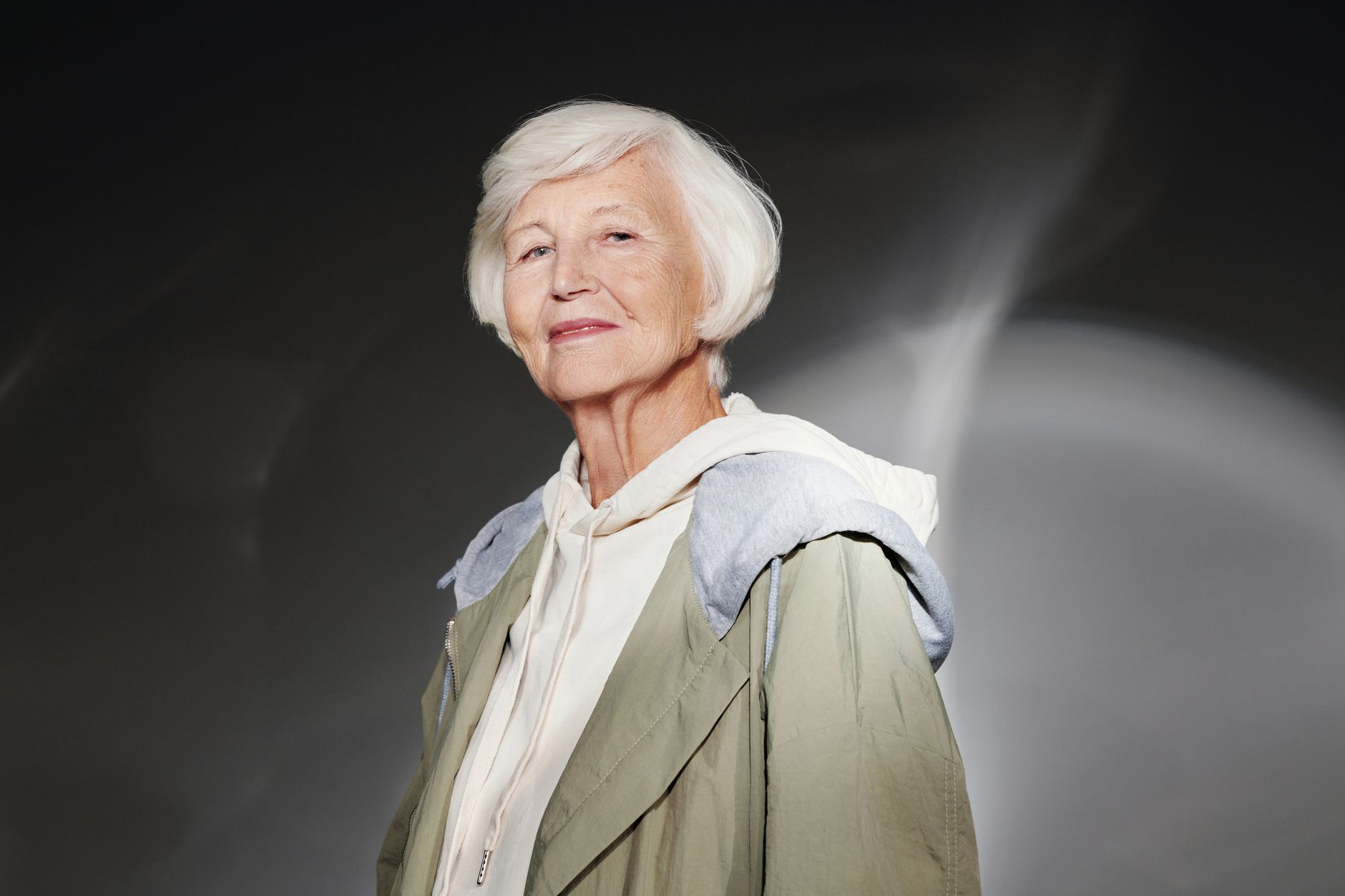 Portrait of a confident senior woman with white hair in fashionable outerwear.